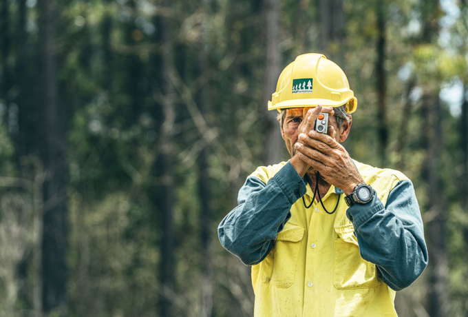 HQP team member looks through a measuring device towards the camera.
