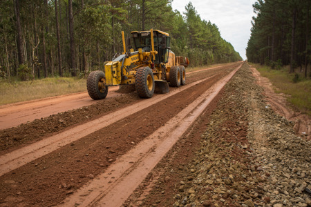 A grader resheeting a plantation road